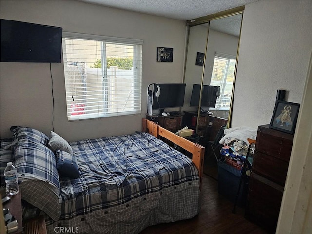 bedroom with a closet and dark hardwood / wood-style flooring