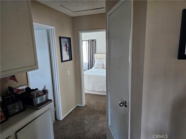 hallway featuring a textured ceiling and carpet flooring