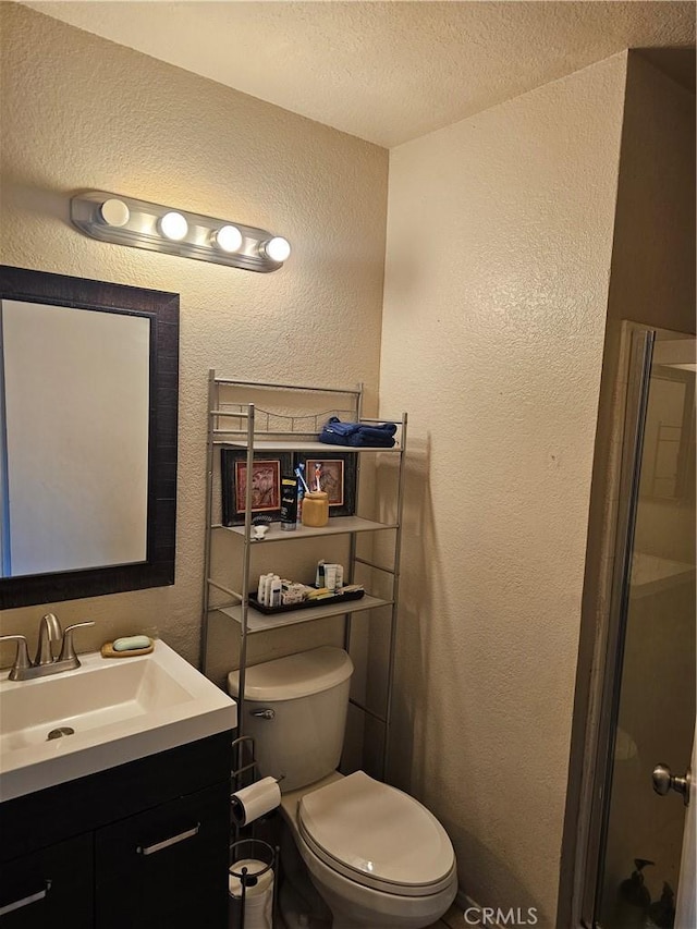 bathroom featuring a textured ceiling, toilet, and vanity