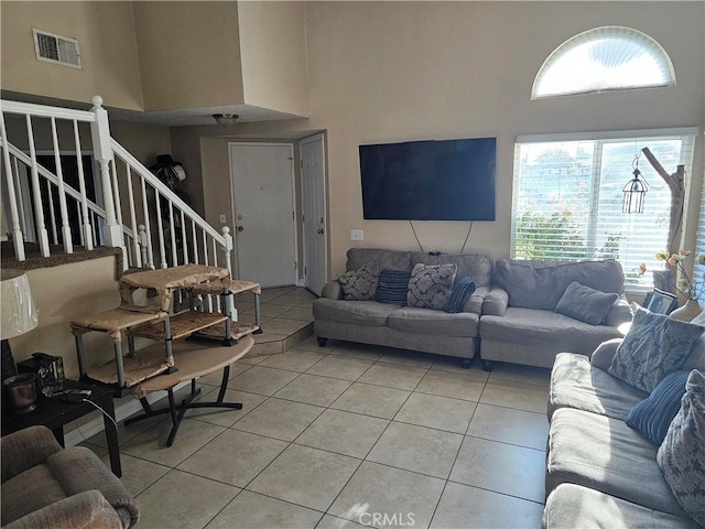 living room featuring tile patterned flooring and a towering ceiling