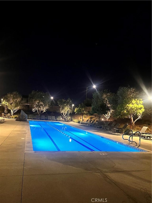 pool at twilight with a patio