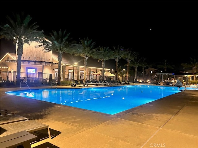 pool at twilight featuring a patio area