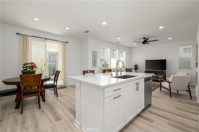 kitchen with ceiling fan, a center island with sink, stainless steel dishwasher, sink, and white cabinets