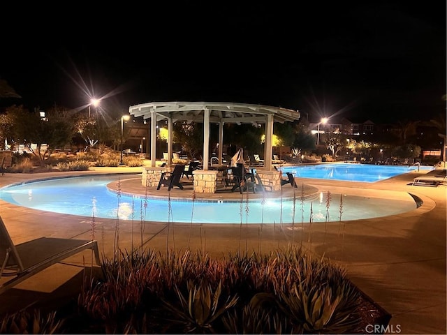 32879 Brunello Way, Temecula, CA 92591 - pool at night with a community pool, a pergola, and a patio
