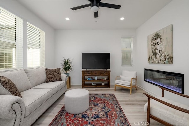 living room with ceiling fan and light hardwood / wood-style flooring