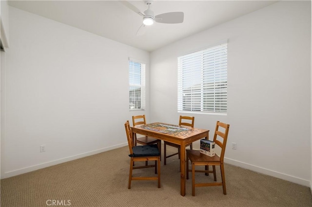 carpeted dining area featuring ceiling fan