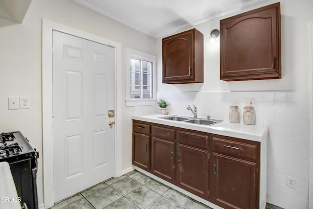 kitchen with sink, light tile patterned floors, and stove