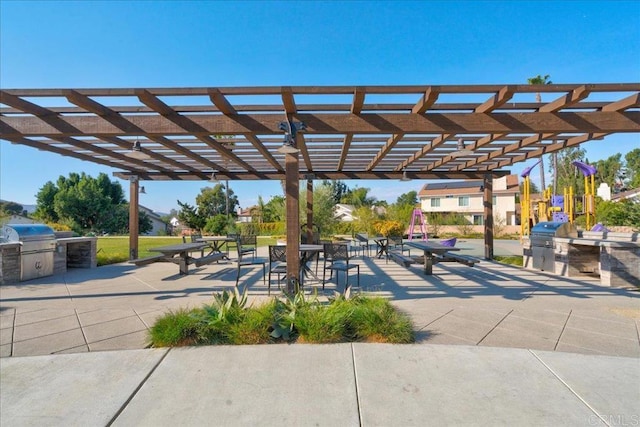 view of community with a pergola, a patio, and an outdoor kitchen