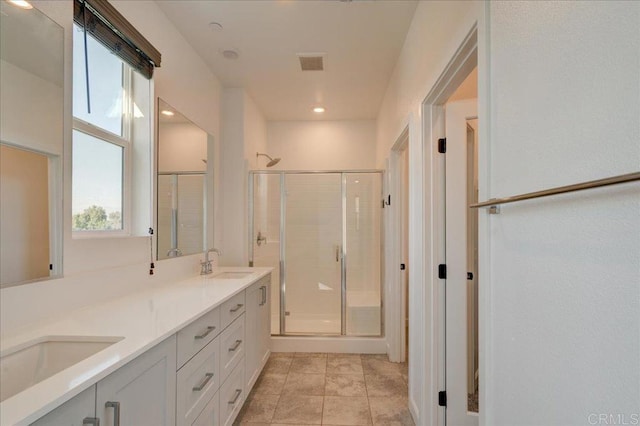 bathroom with vanity and a shower with door