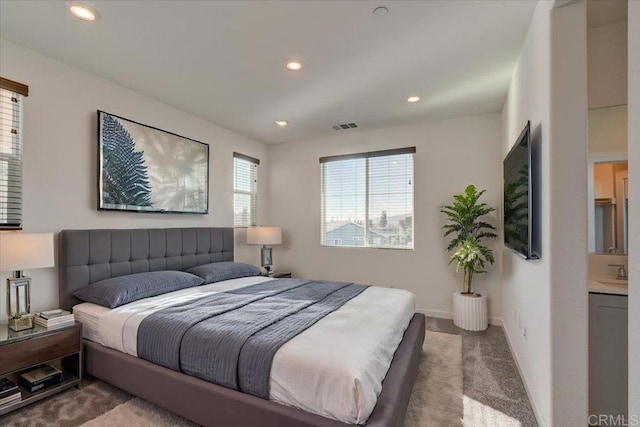 bedroom featuring carpet, ensuite bathroom, and sink