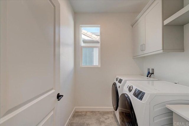 clothes washing area featuring cabinets and separate washer and dryer