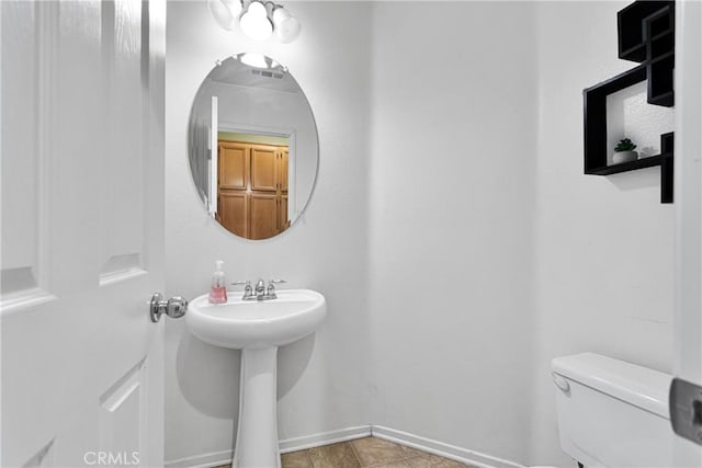 bathroom with toilet and tile patterned flooring