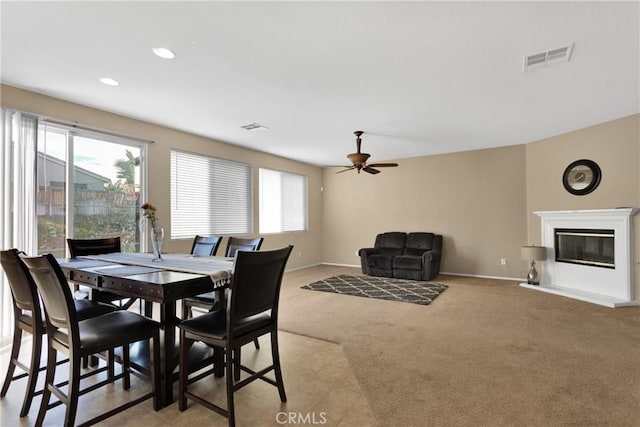 carpeted dining area featuring ceiling fan