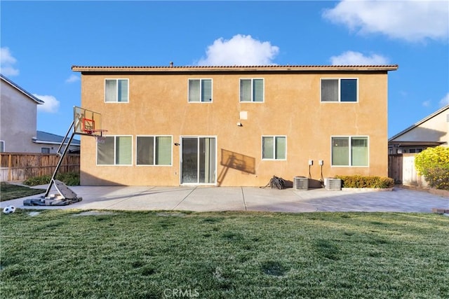 rear view of house featuring a lawn and a patio