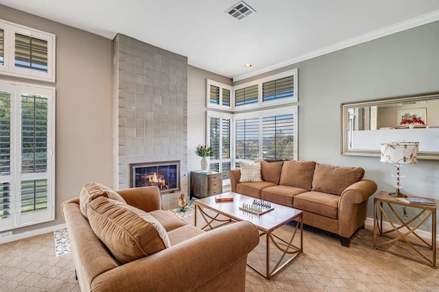 living room with ornamental molding and a tiled fireplace