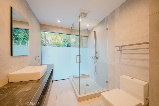 bathroom with tile patterned floors, tile walls, and walk in shower