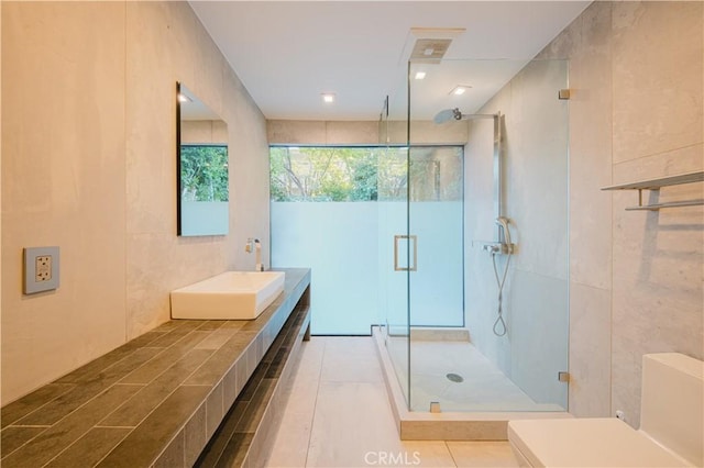 bathroom featuring sink, tile walls, and walk in shower