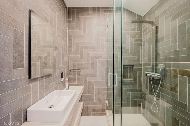 bathroom featuring a shower with door, tile patterned floors, and tile walls