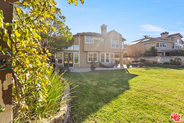 rear view of property with a yard and a patio