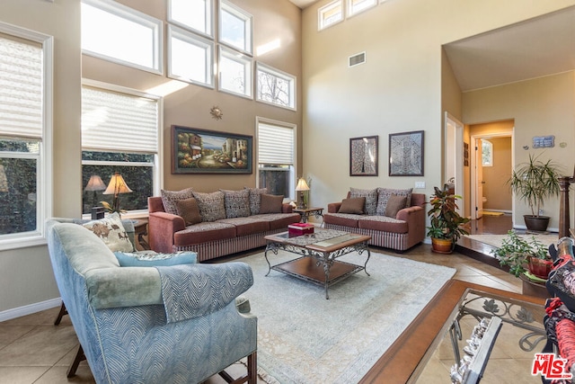 tiled living room with a towering ceiling and plenty of natural light