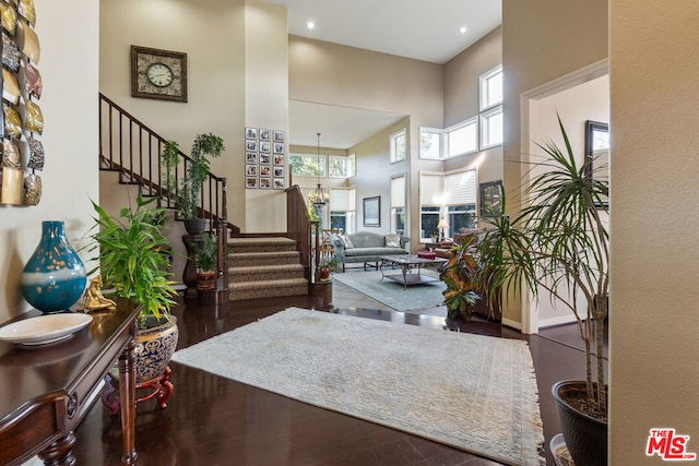 foyer featuring a chandelier, a towering ceiling, and dark hardwood / wood-style floors