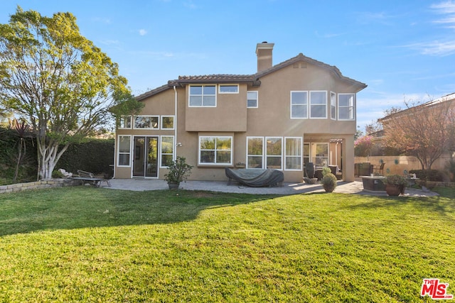 rear view of property with a yard and a patio area