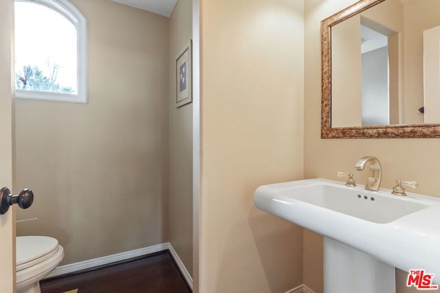 bathroom featuring hardwood / wood-style flooring, toilet, and sink