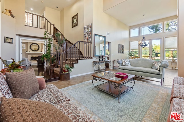 tiled living room with a high ceiling and an inviting chandelier