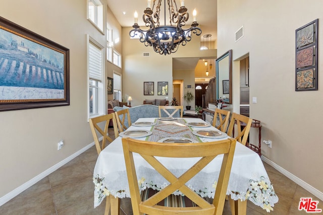 dining room featuring a chandelier, a high ceiling, and tile patterned flooring