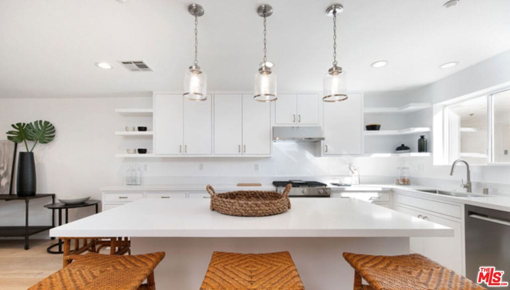 kitchen featuring a breakfast bar, white cabinetry, and stainless steel dishwasher