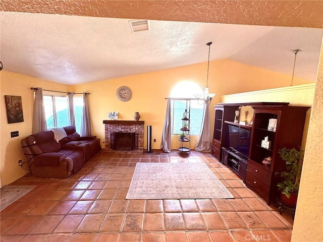 living room featuring lofted ceiling, a chandelier, a textured ceiling, and a brick fireplace