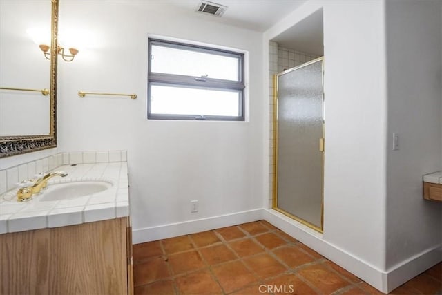 bathroom with tile patterned floors, vanity, and walk in shower