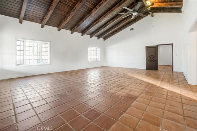 tiled spare room with beamed ceiling, a healthy amount of sunlight, and high vaulted ceiling