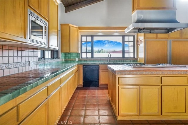 kitchen featuring stainless steel appliances, tile countertops, extractor fan, lofted ceiling, and decorative backsplash