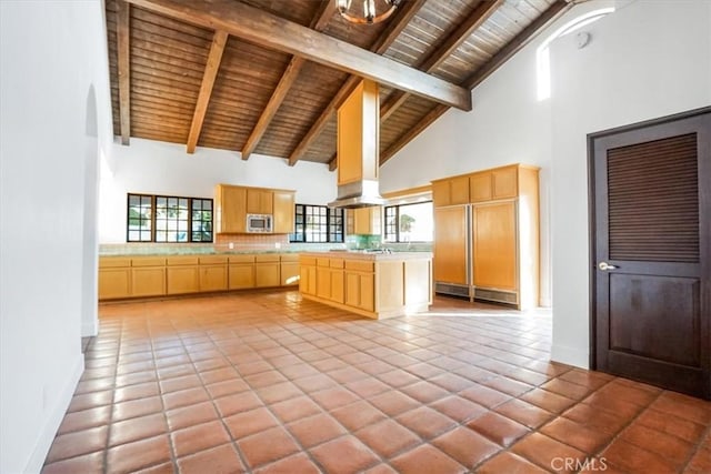 kitchen with light brown cabinetry, high vaulted ceiling, wooden ceiling, beamed ceiling, and stainless steel microwave