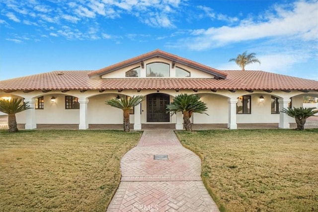 mediterranean / spanish home with a front yard