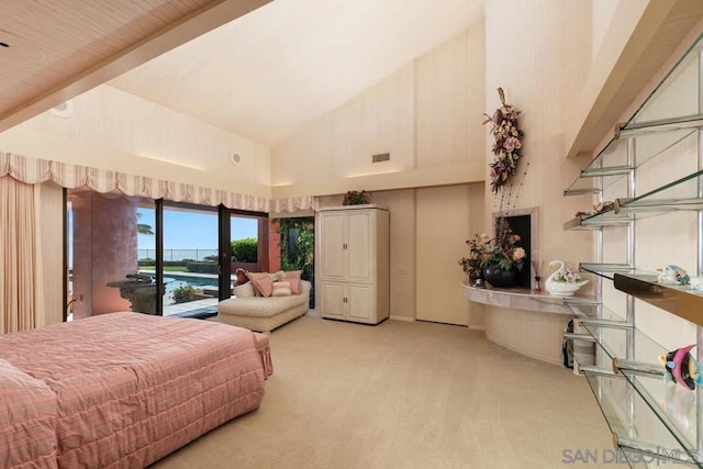 bedroom with access to exterior, a water view, light colored carpet, and high vaulted ceiling