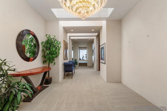 hall with light carpet and an inviting chandelier