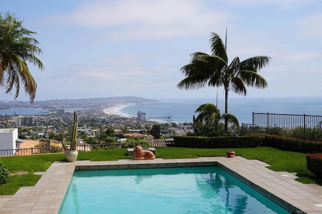 view of swimming pool with a lawn and a water view