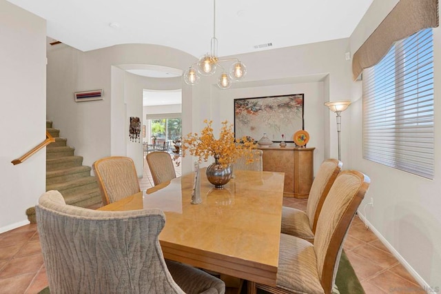 dining room featuring light tile patterned floors, a healthy amount of sunlight, and a notable chandelier