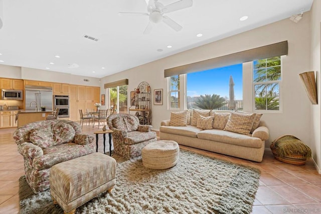 living room featuring sink, ceiling fan, and light tile patterned flooring