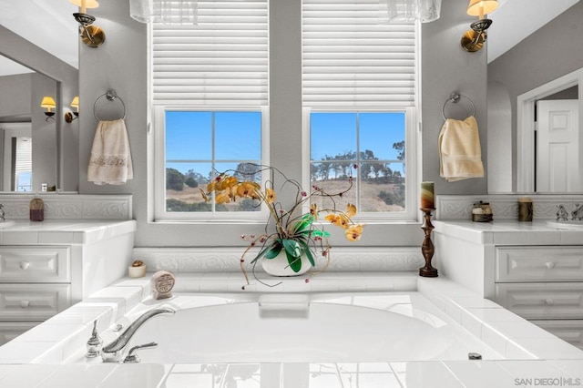 bathroom with vanity and tiled tub