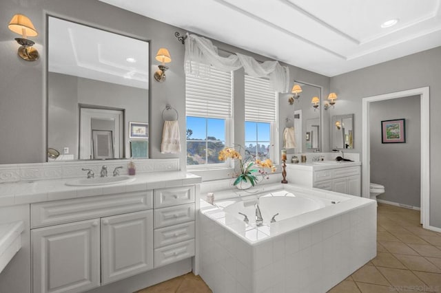 bathroom featuring tile patterned floors, vanity, toilet, and tiled tub