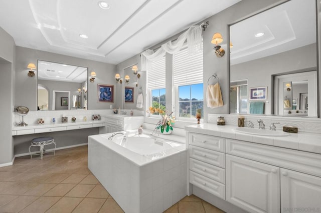 bathroom with tile patterned flooring, vanity, and a relaxing tiled tub