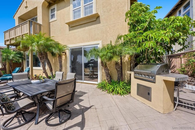 view of patio with an outdoor kitchen, a balcony, and a grill