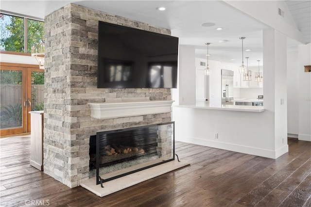 living room with a fireplace, french doors, dark hardwood / wood-style flooring, and vaulted ceiling