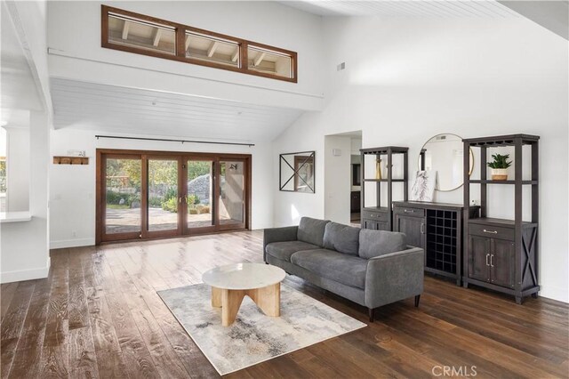 living room with french doors, dark wood-type flooring, and a high ceiling