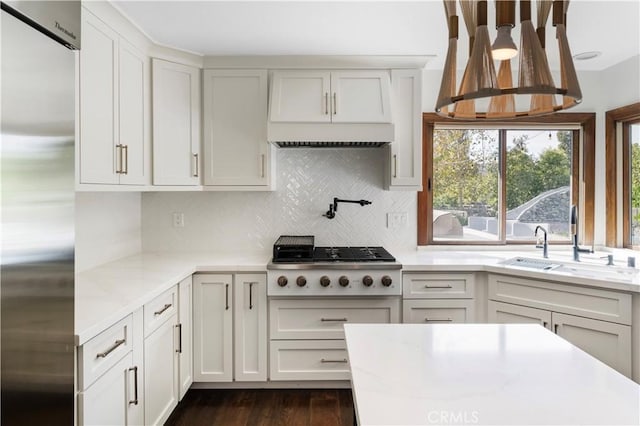 kitchen with tasteful backsplash, sink, white cabinets, and appliances with stainless steel finishes