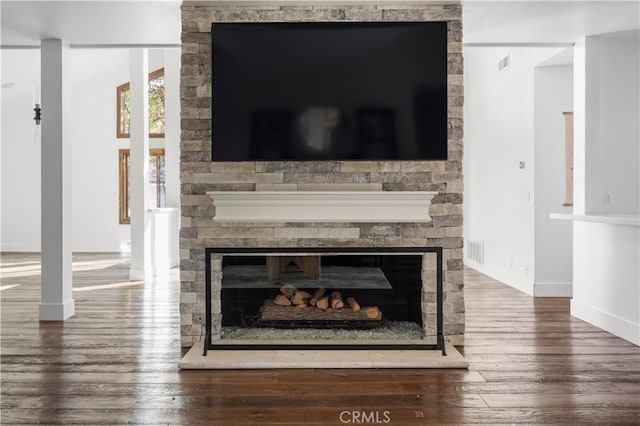 interior details featuring hardwood / wood-style floors and a stone fireplace