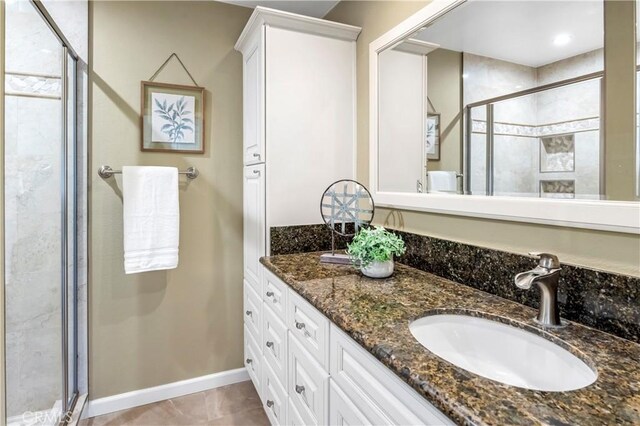 bathroom featuring tile patterned flooring, vanity, and an enclosed shower